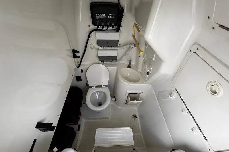 Slide: The Image of 2003 Triton 2895 CC boat interior with toilet, sink, and storage compartments. - 49