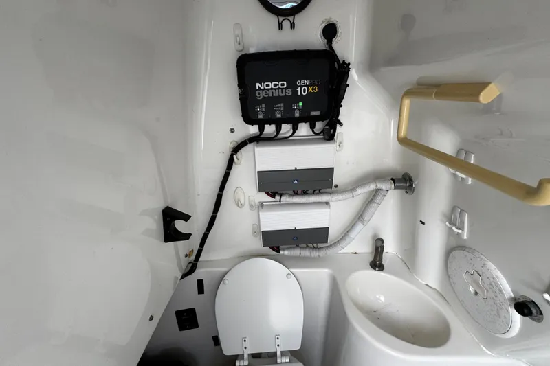 Slide: The Image of Interior of 2003 Triton 2895 CC boat with toilet, sink, and NOCO Genius charger. - 51