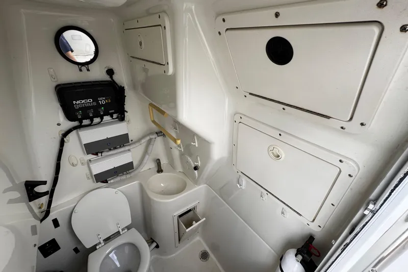 Slide: The Image of Interior of 2003 Triton 2895 CC boat with toilet, sink, and storage compartments. - 52