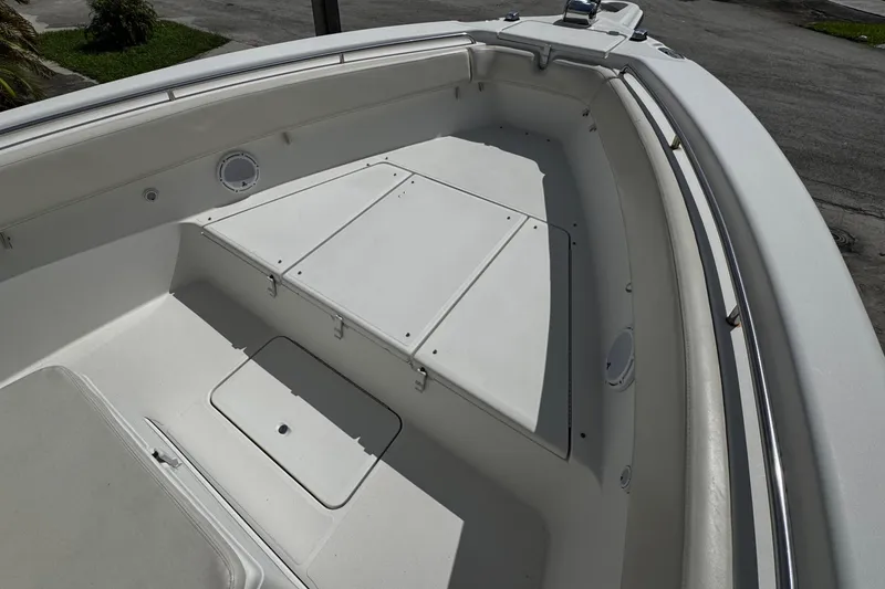 Slide: The Image of 2003 Triton 2895 CC boat deck, featuring spacious storage compartments and sleek design. - 56