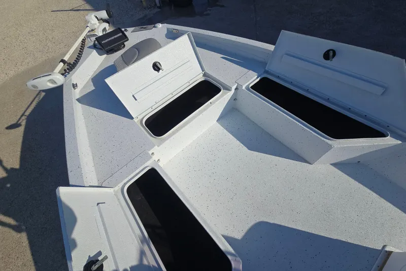 Slide: The Image of 2019 Xpress H24B boat deck with open storage compartments and trolling motor. - 12