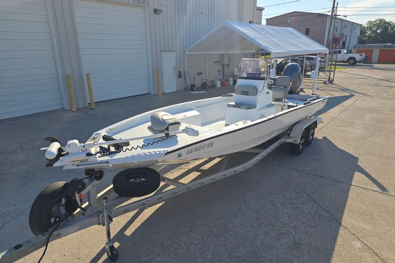 Slide: The Image of 2019 Xpress H24B boat on trailer outside a warehouse, under a canopy. - 7