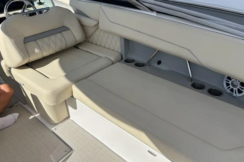 Slide: The Image of 2023 Regal LX6 boat interior with beige seating and cup holders. - 13