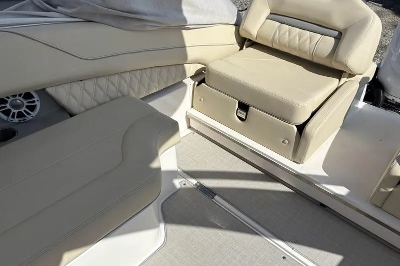Slide: The Image of 2023 Regal LX6 boat interior with beige seating and storage compartment. - 15