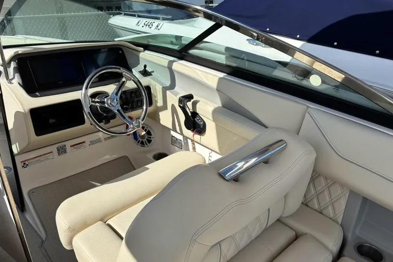 Slide: The Image of 2023 Regal LX6 boat interior with steering wheel and beige seating. - 7