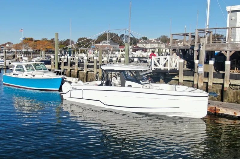 Slide: The Image of 2026 Wellcraft 38 T-Top boat cruising in a marina with clear blue water. - 27