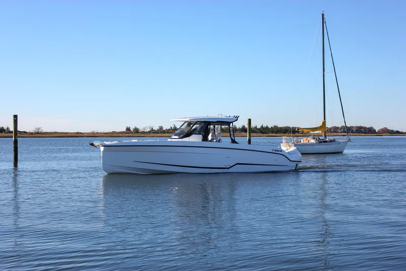 Slide: The Image of 2026 Wellcraft 38 T-Top boat docked in a marina, surrounded by other vessels. - 28