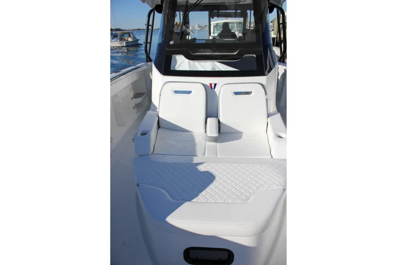 Slide: The Image of 2026 Wellcraft 38 T-Top boat on calm water, sunny day, marina background. - 35