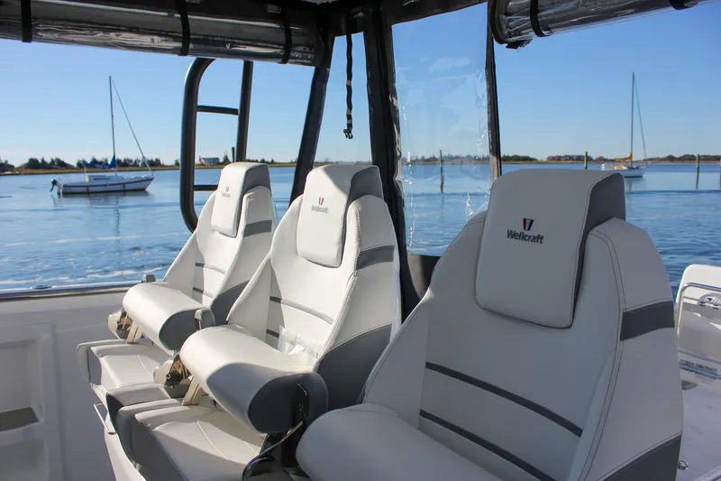 Slide: The Image of 2026 Wellcraft 38 T-Top boat interior with modern helm and seating, docked by the water. - 36