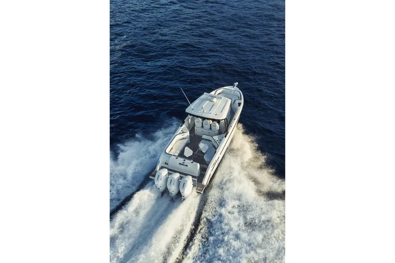 Slide: The Image of 2026 Wellcraft 38 T-Top boat docked in a marina under a cloudy sky. - 4