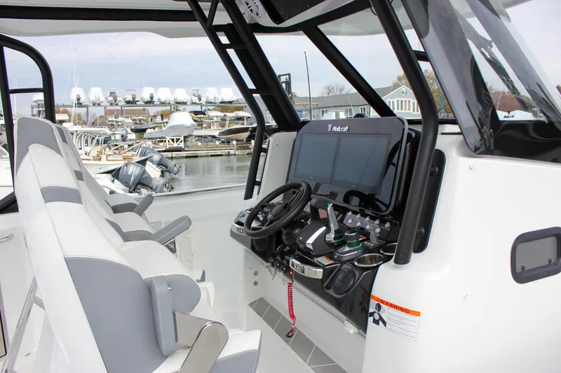 Slide: The Image of 2026 Wellcraft 38 T-Top boat interior with modern helm and seating at marina. - 53