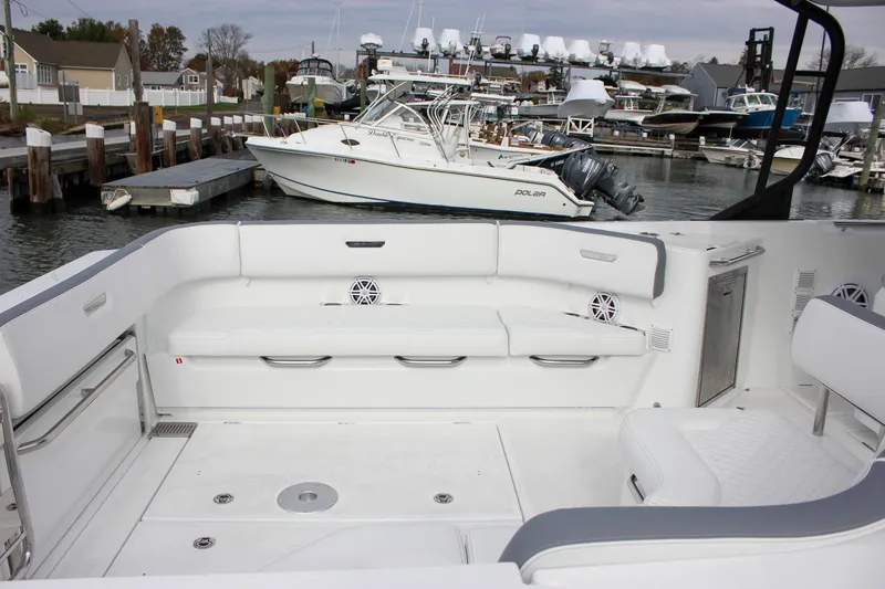 Slide: The Image of 2026 Wellcraft 38 T-Top boat interior with white seating at a marina. - 58