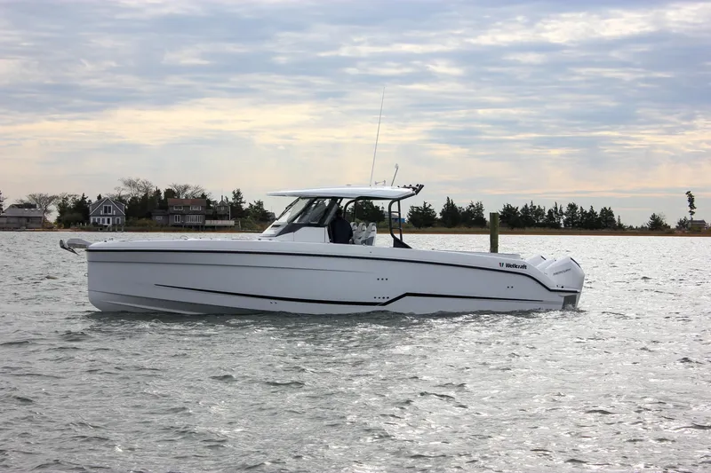 Slide: The Image of 2026 Wellcraft 38 T-Top boat cruising on a calm lake under a cloudy sky. - 62