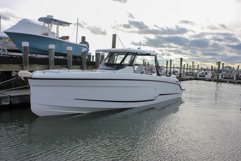 Slide: The Image of 2026 Wellcraft 38 T-Top boat docked in a marina under cloudy skies. - 63