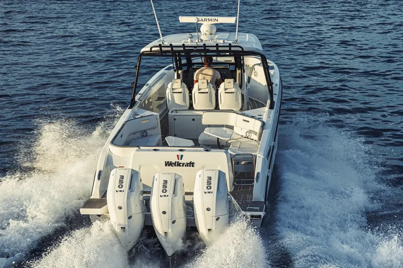 Slide: The Image of 2026 Wellcraft 38 T-Top boat cruising on open water, rear view. - 69