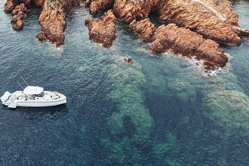 Slide: The Image of 2026 Wellcraft 38 T-Top boat interior with seating, docked in a serene marina. - 9