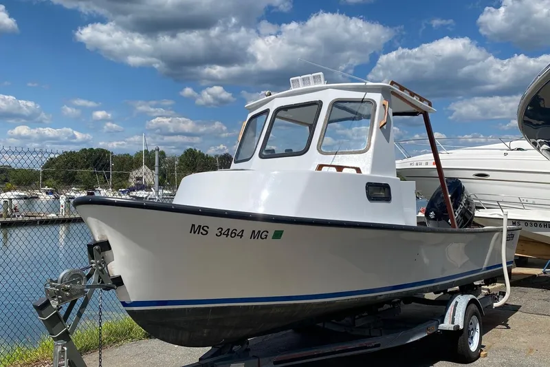 The Image of 1991 Eastern Lobsterman boat on trailer, dockside, under a partly cloudy sky. - 0