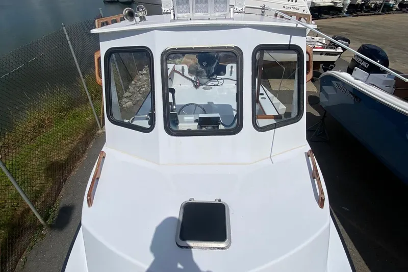 Slide: The Image of 1991 Eastern Lobsterman boat with white cabin and windows, docked near water. - 7