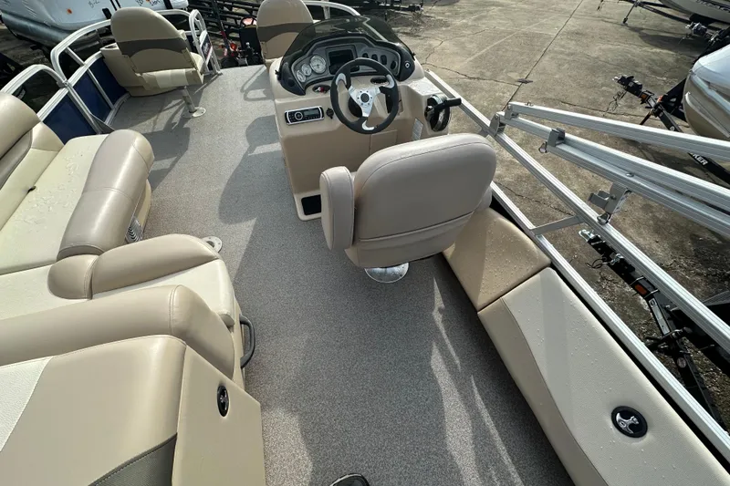 Slide: The Image of 2015 Sun Tracker Fishin' Barge 22 DLX interior with beige seating and steering console. - 12