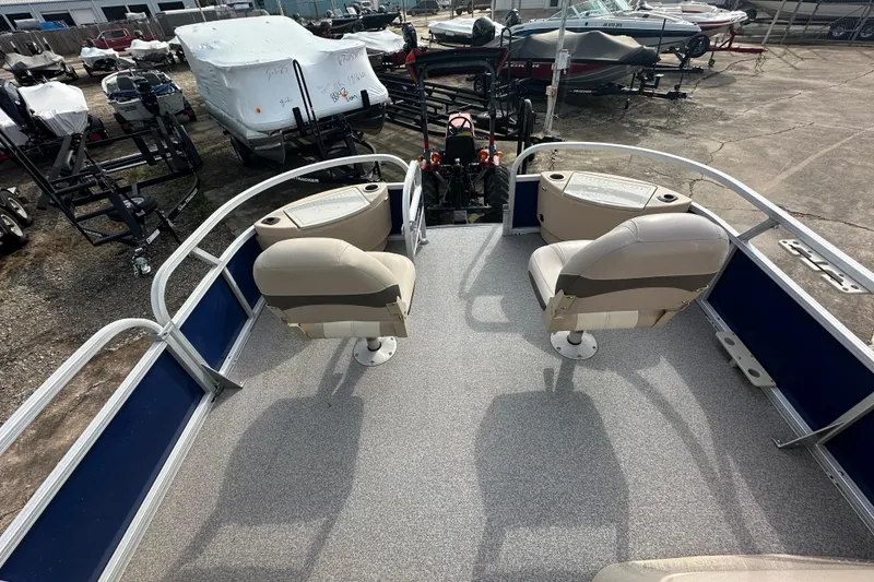 Slide: The Image of 2015 Sun Tracker Fishin' Barge 22 DLX with two swivel seats, docked in a boatyard. - 15