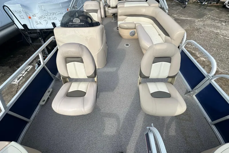 Slide: The Image of 2015 Sun Tracker Fishin' Barge 22 DLX interior with beige seating and helm. - 16