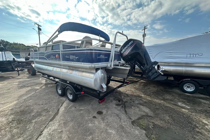 Slide: The Image of 2015 Sun Tracker Fishin' Barge 22 DLX pontoon boat with Mercury outboard motor on trailer. - 2