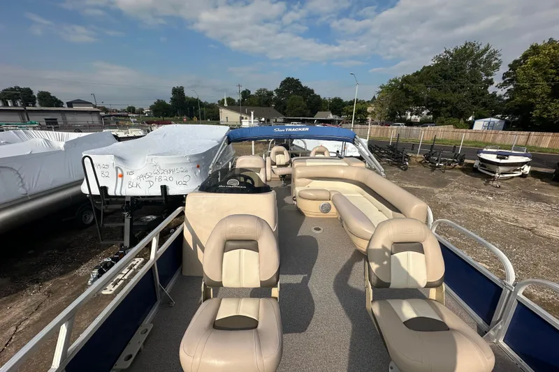 Slide: The Image of 2015 Sun Tracker Fishin' Barge 22 DLX pontoon boat with beige seating and blue accents. - 6