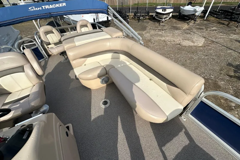 Slide: The Image of 2015 Sun Tracker Fishin' Barge 22 DLX with beige seating and blue canopy. - 7