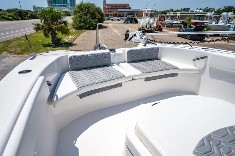 Slide: The Image of 2022 Twin Vee 280 GFX CC boat with cushioned seating, docked near a marina. - 12