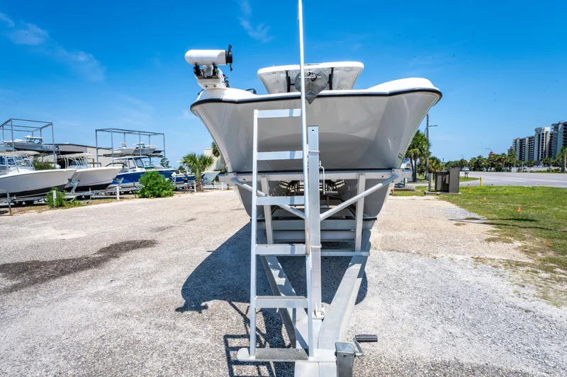 Slide: The Image of 2022 Twin Vee 280 GFX CC boat on trailer, parked outdoors under clear blue sky. - 16