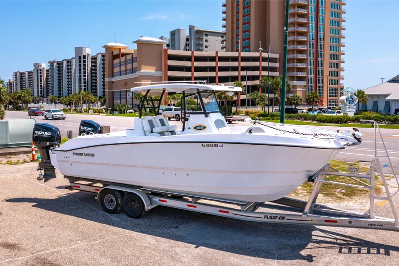Slide: The Image of 2022 Twin Vee 280 GFX CC boat on trailer, parked in marina lot. - 2