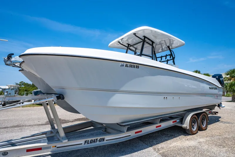 Slide: The Image of 2022 Twin Vee 280 GFX CC boat on trailer under clear blue sky. - 3