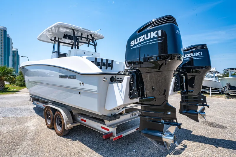 Slide: The Image of 2022 Twin Vee 280 GFX CC boat with dual Suzuki 300 engines on a trailer. - 6