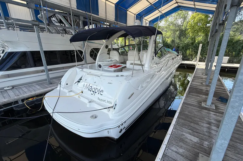 Slide: The Image of 2006 Sea Ray 340 Sundancer docked under a canopy, featuring sleek white design. - 2