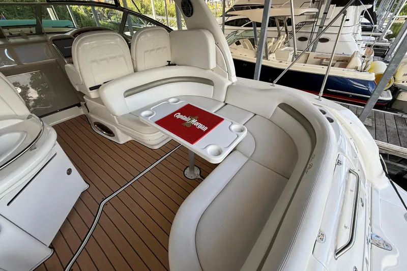 Slide: The Image of 2006 Sea Ray 340 Sundancer interior with white seating and wooden deck. - 4