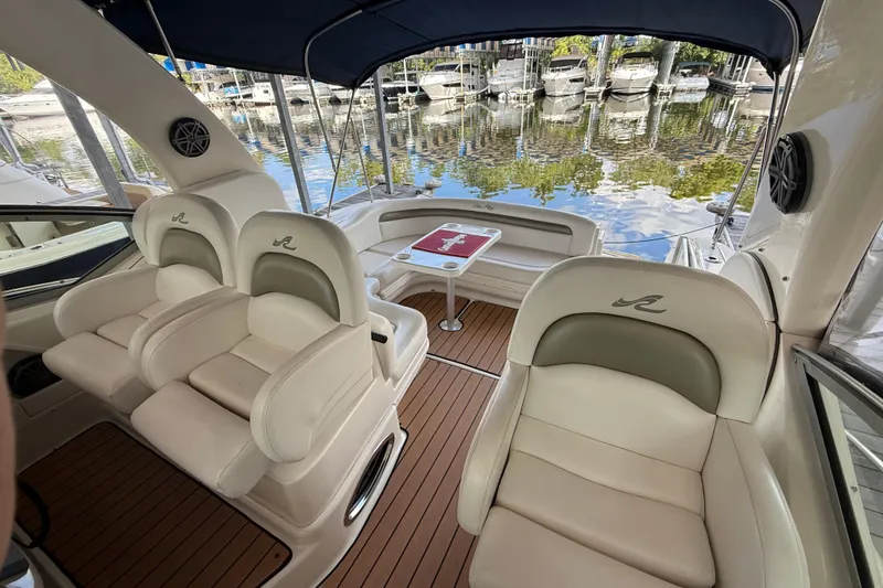 Slide: The Image of 2006 Sea Ray 340 Sundancer interior with plush seating and scenic marina view. - 5