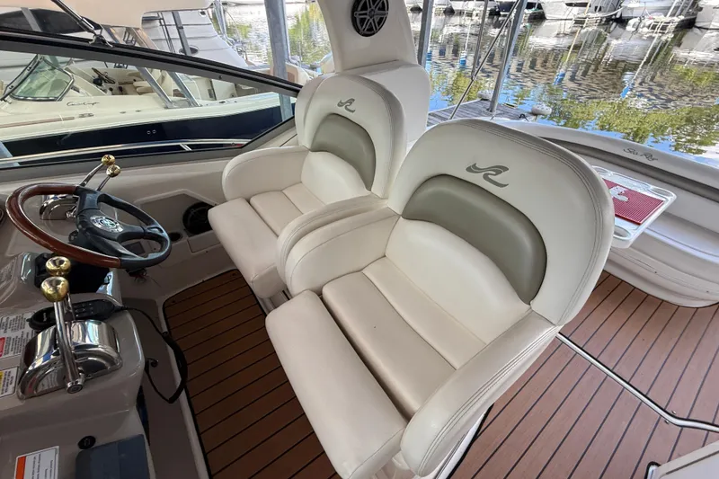 Slide: The Image of 2006 Sea Ray 340 Sundancer cockpit with dual helm seats and wooden deck. - 6