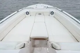 Slide: The Image of 2026 Grady-White Freedom 325 boat interior with cushioned seating on calm water. - 14