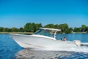 Slide: The Image of 2026 Grady-White Freedom 325 cruising on a serene lake under a clear blue sky. - 6