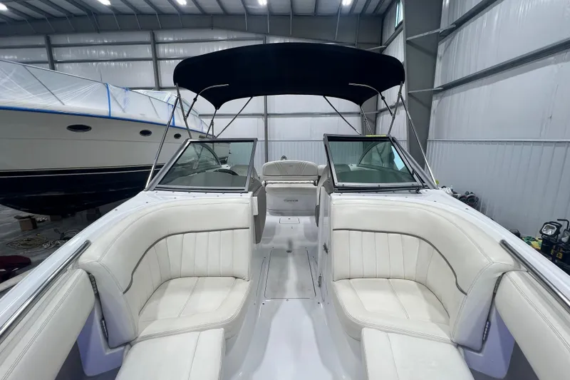 Slide: The Image of 2006 Cobalt 232 boat interior with white seating, stored indoors. - 11