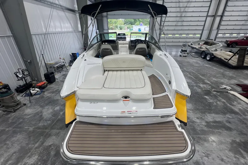 Slide: The Image of 2006 Cobalt 232 boat in a storage facility, featuring a spacious deck and seating area. - 4