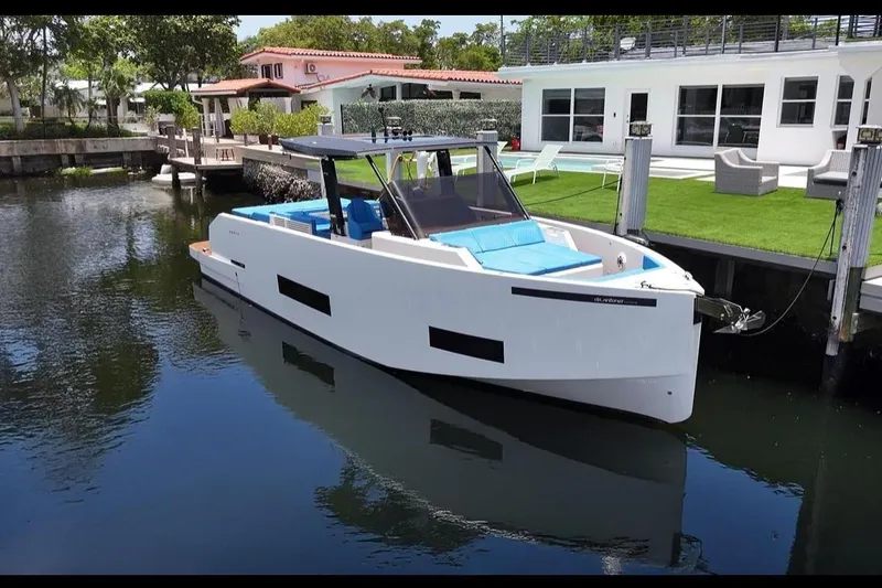 The Image of 2021 De Antonio Yachts Center Console docked by modern waterfront home. - 1