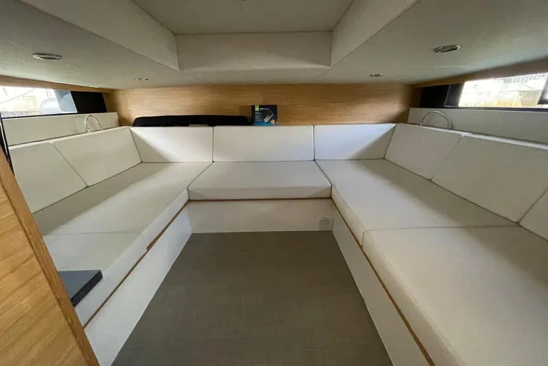 Slide: The Image of Interior of 2021 De Antonio Yachts Center Console with white seating and wooden accents. - 18