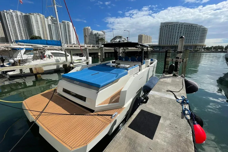 Slide: The Image of 2021 De Antonio Yachts Center Console docked in a marina with cityscape background. - 2