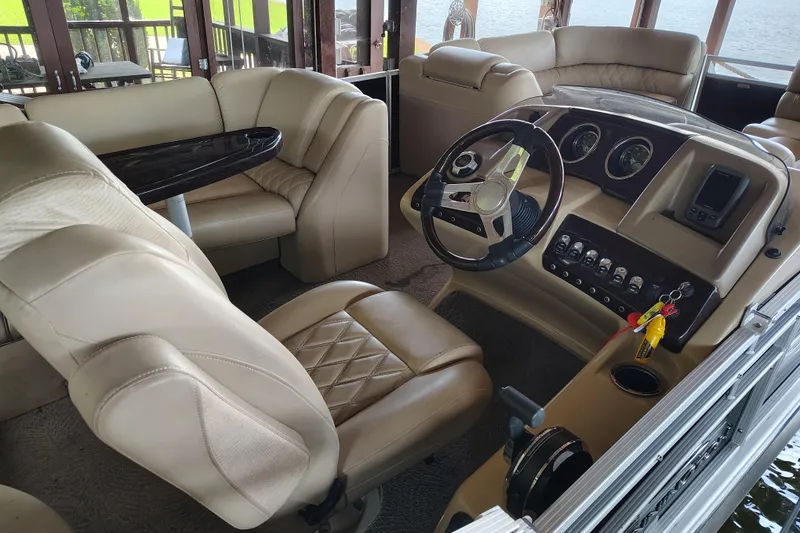 Slide: The Image of 2014 Bennington 2575 QCW I/O boat interior with beige seating and control panel. - 13