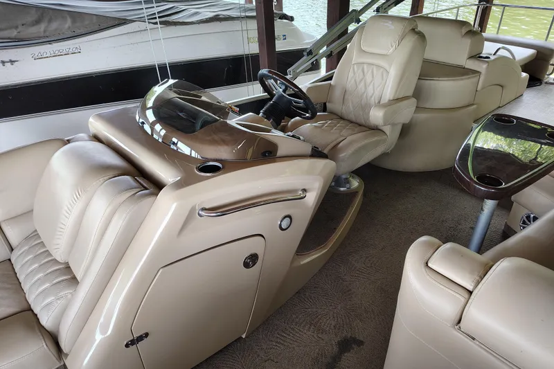 Slide: The Image of Interior of a 2014 Bennington 2575 QCW I/O boat with luxurious seating and steering console. - 19