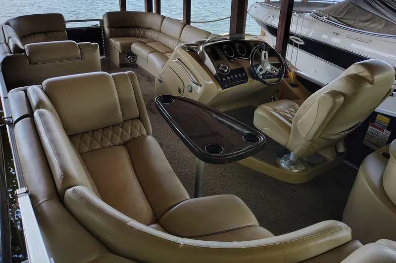 Slide: The Image of Luxurious interior of a 2014 Bennington 2575 QCW I/O boat with plush seating and steering console. - 2