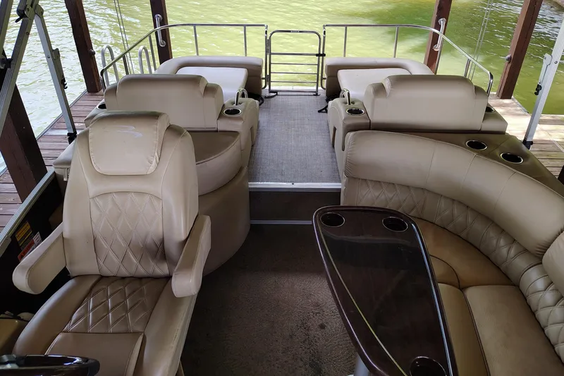 Slide: The Image of Interior of a 2014 Bennington 2575 QCW I/O pontoon boat with beige seating. - 25