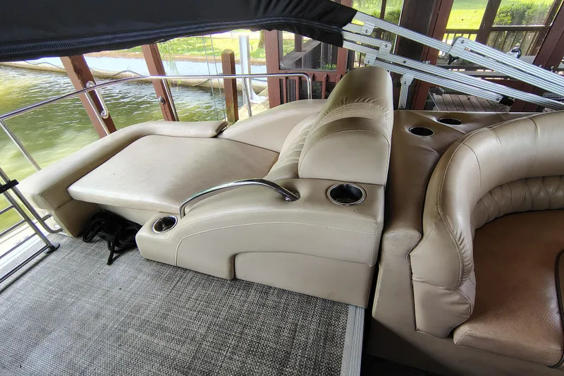 Slide: The Image of 2014 Bennington 2575 QCW I/O boat interior with beige seating and cup holders. - 30