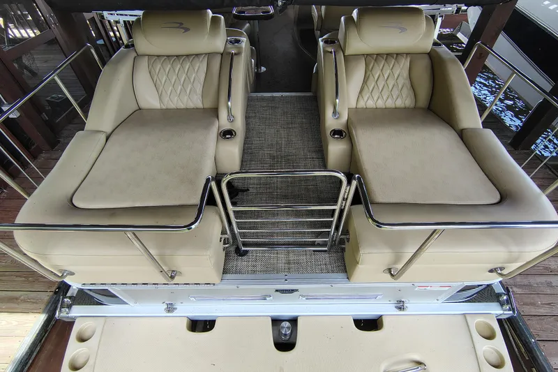 Slide: The Image of 2014 Bennington 2575 QCW I/O boat interior with beige seating and metal railings. - 33